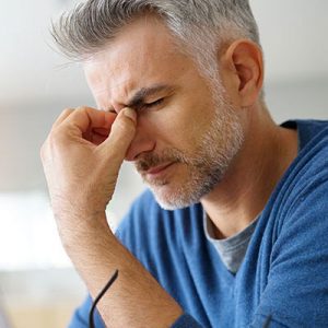 guy pinching between eyes due to a migraine - headaches and botox therapy in Ottawa